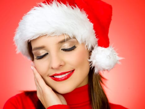 Portrait of beautiful woman wearing santa claus hat on red background