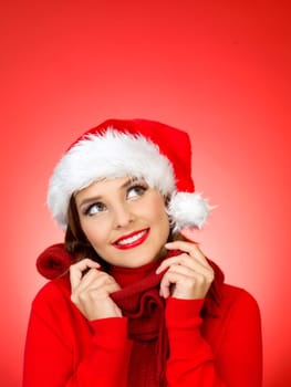 Portrait of beautiful woman wearing santa claus hat on red background
