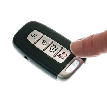 Finger pressing alarm on black modern car door opener and keyless entry device