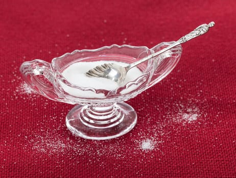 Table salt crystals in cut glass bowl on red tablecloth