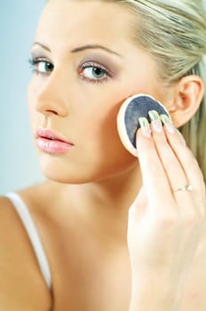Portrait of blonde young sexy woman doing makeup