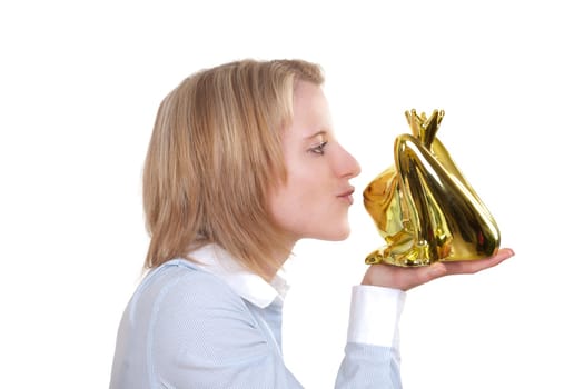 Young blonde woman holding a golden frog in her hand and wants to kiss them