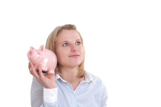 Young blonde woman holding a piggy bank and pondering