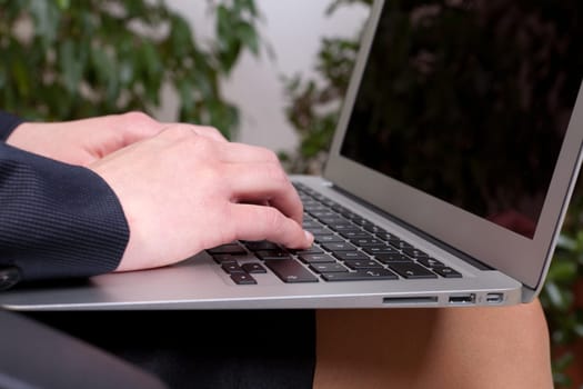 Young businesswoman with a notebook on her knees working on