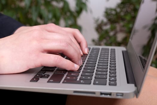 Young businesswoman with a notebook on her knees working on
