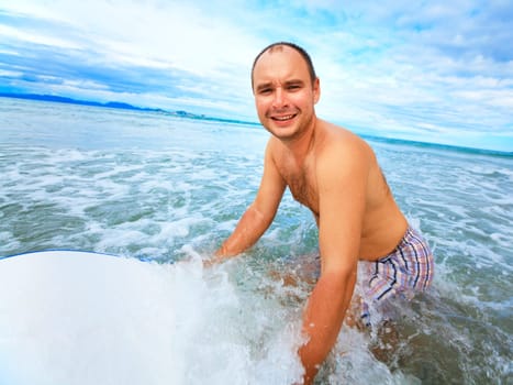 Happy man with body board on the waves