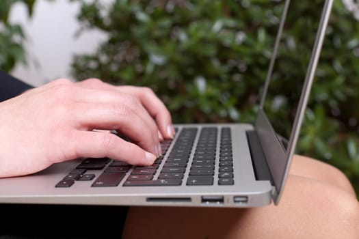 Young businesswoman with a notebook on her knees working on
