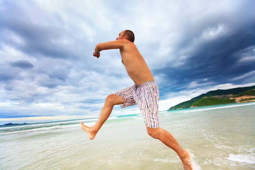 Funny man is running to the ocean