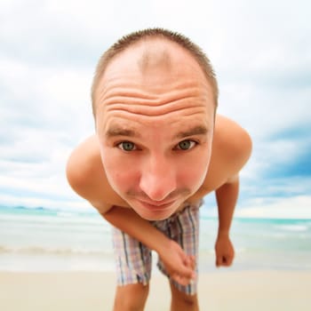 Funny man is looking from the beach