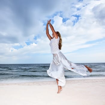 Young woman is dancing on the beach