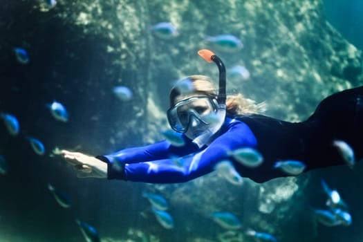Woman swimming underwater with snorkel and mask