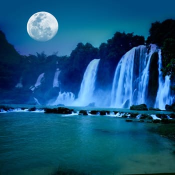 Beautiful waterfall under moonlight at night time