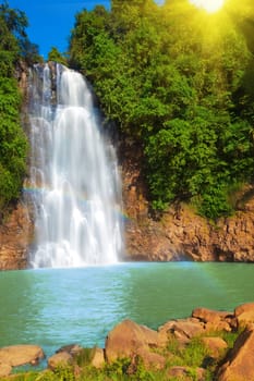 Waterfall with rainbow in rain forest