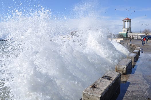 Sea waves breaking on concrete port with spray