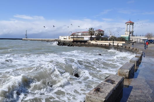 Sea waves breaking on concrete port with spray