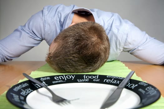 Man falls asleep on a table after eating