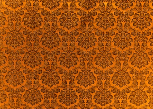 Abstract background of a heavy copper brocade fabric with interwoven repeat design.