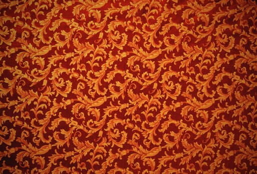 Abstract background of a heavy copper brocade fabric with interwoven repeat design.
