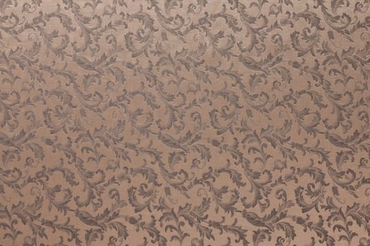 Abstract background of a heavy brown brocade fabric with interwoven repeat design.