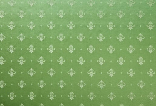 Abstract background of a heavy green brocade fabric with interwoven repeat design.