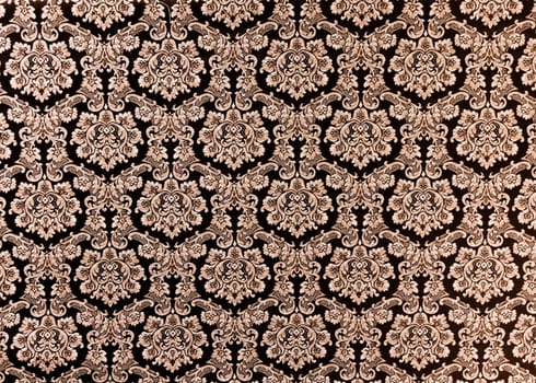 Abstract background of a heavy purple brocade fabric with interwoven repeat design.