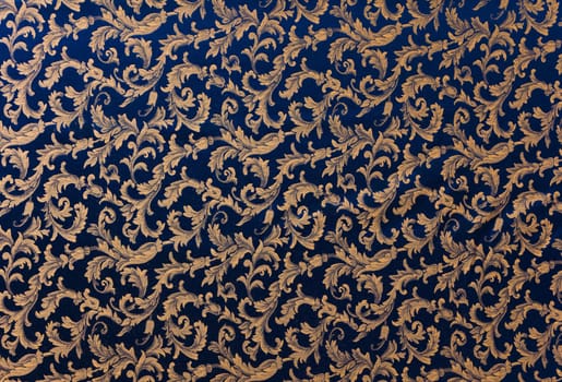 Abstract background of a heavy deep blue brocade fabric with interwoven repeat design.