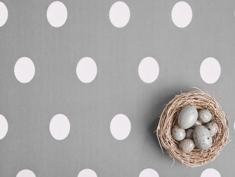 Small nest containing colored eggs over a Easter concept background