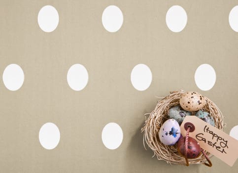 Small nest containing colored eggs over a Easter concept background