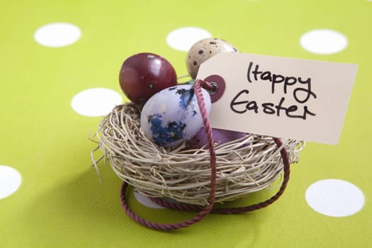 Colored eggs in a small nest with a Happy Easter tag