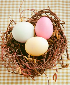 Three boiled dyed Easter Eggs in a nest for happy easter
