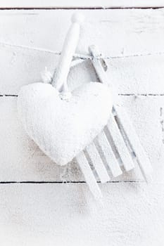 Romantic checked snowy needlework heart for Valentines hanging on snow white boards with copyspace