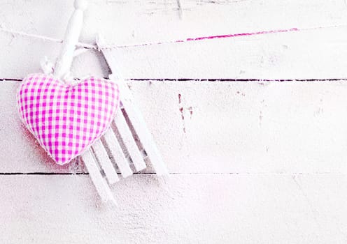 Romantic checked snowy needlework heart for Valentines hanging on snow white boards with copyspace