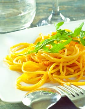 Plate of delicious pasta topped with fresh herbs served ready for dining.