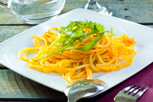 Plate of delicious pasta topped with fresh herbs served ready for dining.