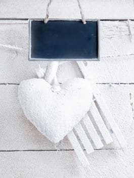 Romantic checked snowy heart for Valentines hanging on snow white boards with tag