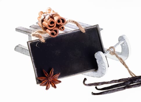 a sleigh with a memo chalkboard and different herbs on white background