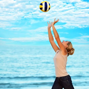 Young woman with ball near the ocean