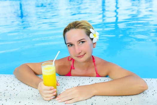 Woman wth moktail relaxing in swimming pool