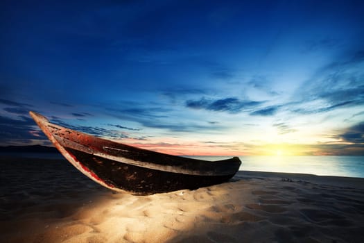 Old fisherman boat at sunrise time on the beach