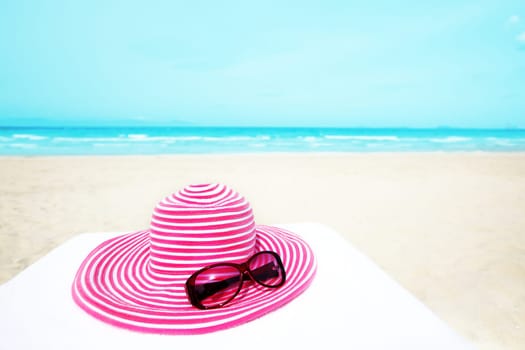 Pink hat and sunglasses near the ocean