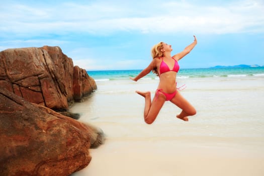 Young woman jumping on the tropical beach