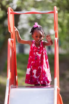 Outdoor Portrait of a cute african american little girl playing at playground