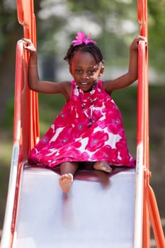 Outdoor Portrait of a cute african american little girl playing at playground