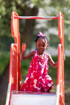 Outdoor Portrait of a cute african american little girl playing at playground