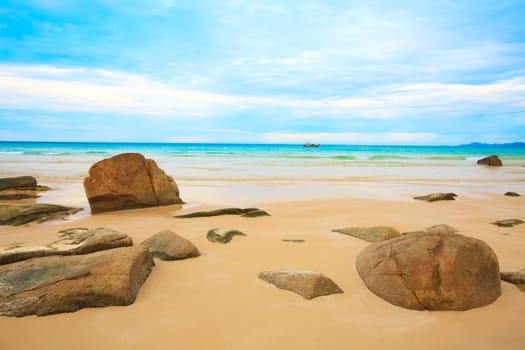 Tropical beach with rock and cloudy sky
