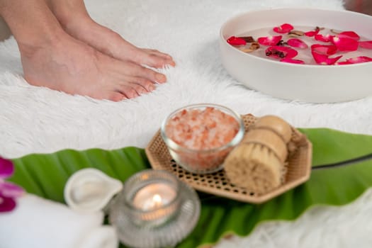 Woman indulges in blissful foot massage at luxurious spa salon while masseur give reflexology therapy in gentle day light ambiance resort or hotel foot spa. Quiescent