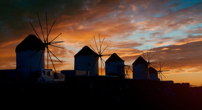 Scenic view of old popular greek windmills on Mykonos island at sunset with picturesque sky