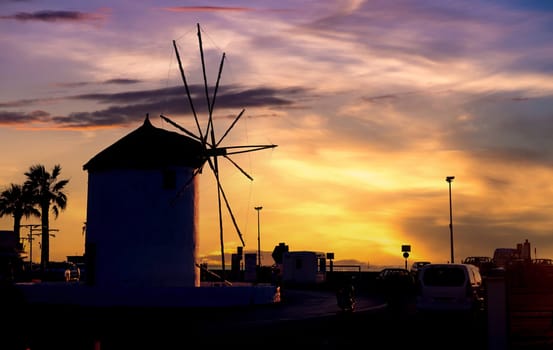 Romantic view of old traditional Greek windmill by the sea at dusk