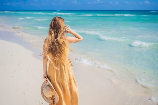 Happy traveller woman in yellow dress enjoys her tropical beach vacation. GO Everywhere.