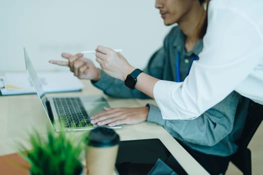 Two business men meeting to talking or discuss marketing work in workplace using paperwork, calculator, computer to work